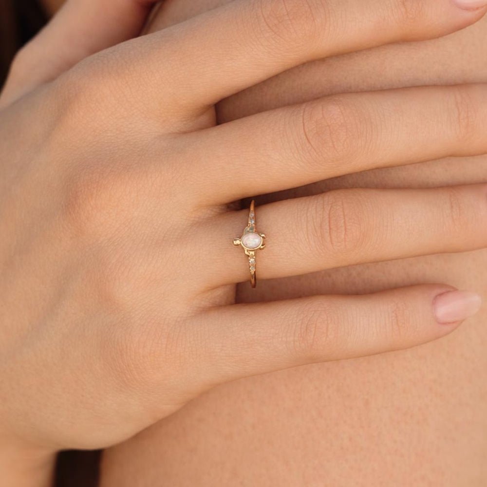 Opal Gold Turtle Ring, worn on a finger, pale opal centre with small stones on the band